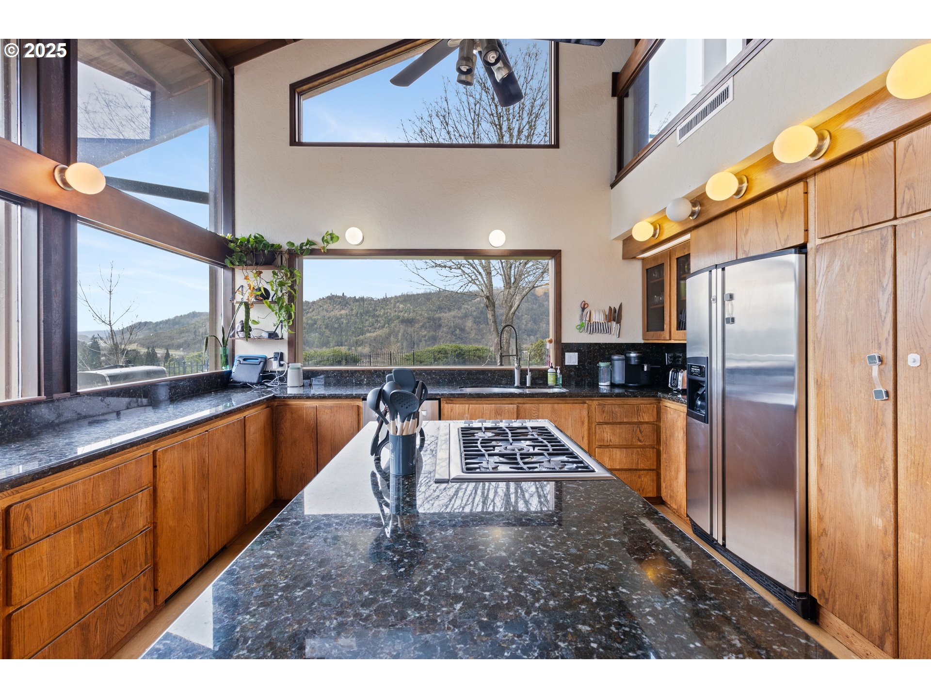 141 Umpqua College Road Roseburg, OR 97470 - Photo 12 of 45 a kitchen with stainless steel appliances granite countertop a refrigerator a stove and a sink with wooden cabinets