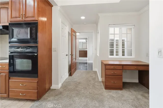 a room with furniture a flat screen tv and kitchen view