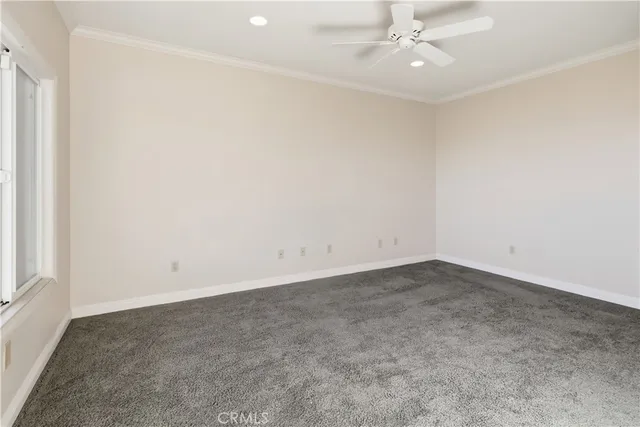 an empty room with a ceiling fan and a window