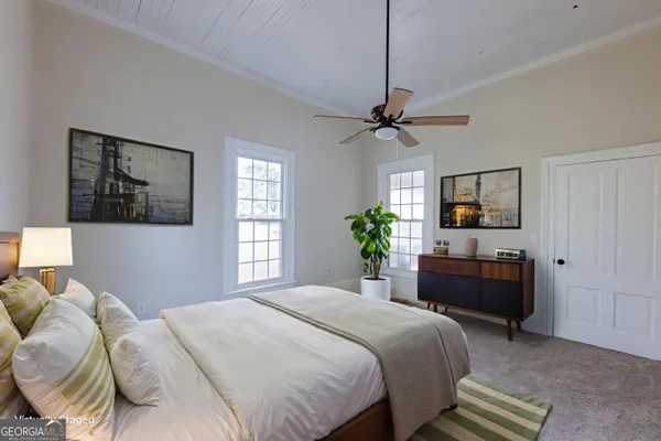 a bedroom with a bed a dresser and chair