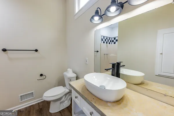 a bathroom with a granite countertop toilet sink and mirror