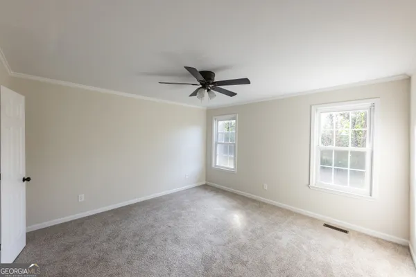 an empty room with a ceiling fan and window