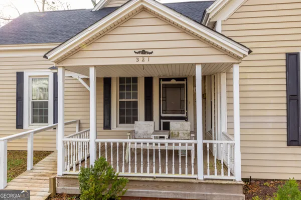 a view of a house with a yard and wooden fence