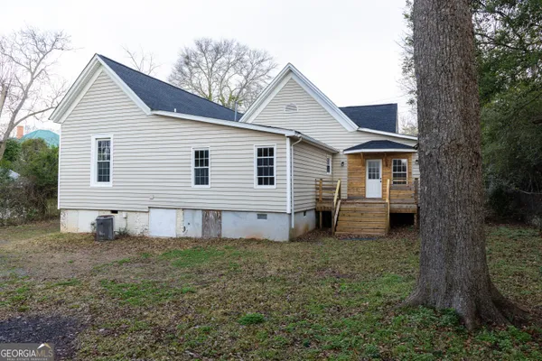 a view of a small house with a yard and stairs