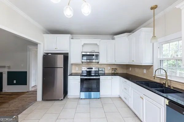 a kitchen with a sink appliances and cabinets