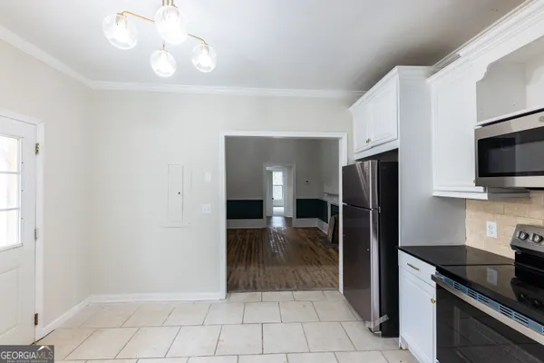 a kitchen with granite countertop a refrigerator and a stove top oven