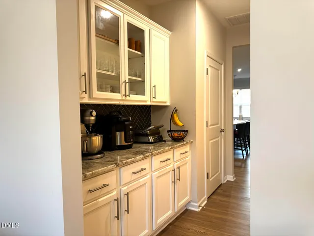 a kitchen with a table chairs refrigerator and cabinets