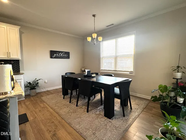 a view of a hallway with wooden floor and a refrigerator