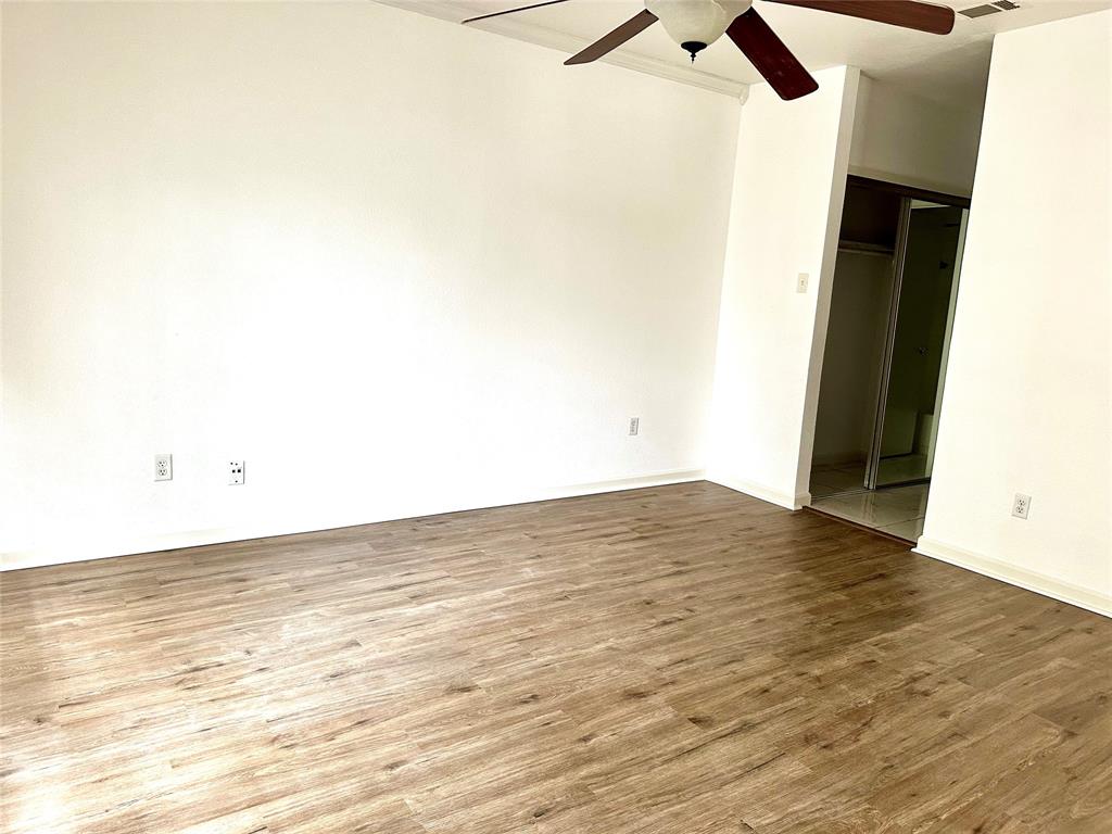 5981 Arapaho Road, Unit 1002 Dallas, TX 75248 - Photo 14 of 16 an empty room with wooden floor and fan