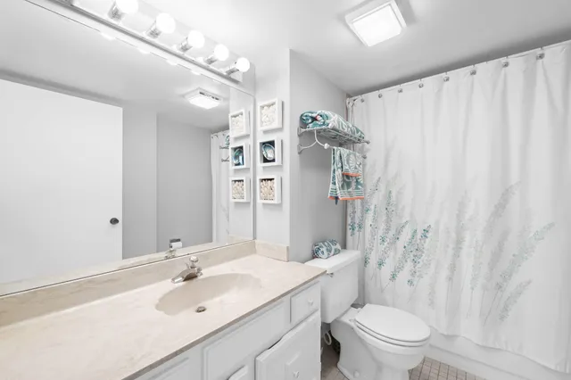 a bathroom with a sink vanity mirror and toilet