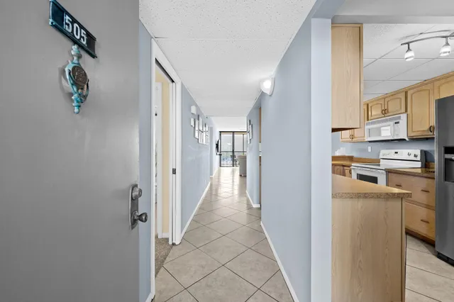 a view of a hallway with kitchen appliances and cabinets