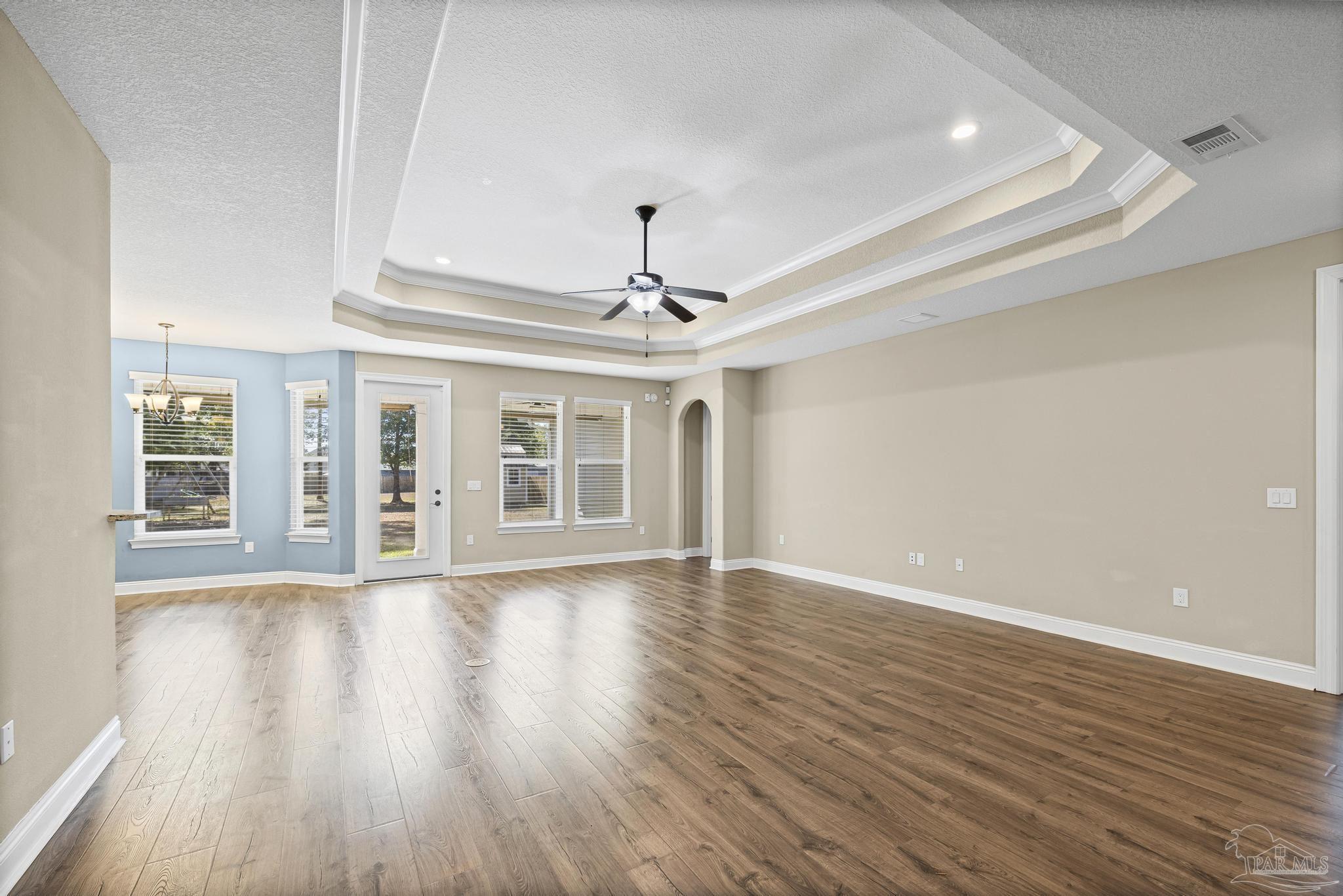 7933 Silver Maple Drive Milton, FL 32583 - Photo 21 of 70 a view of an empty room with wooden floor and a ceiling fan