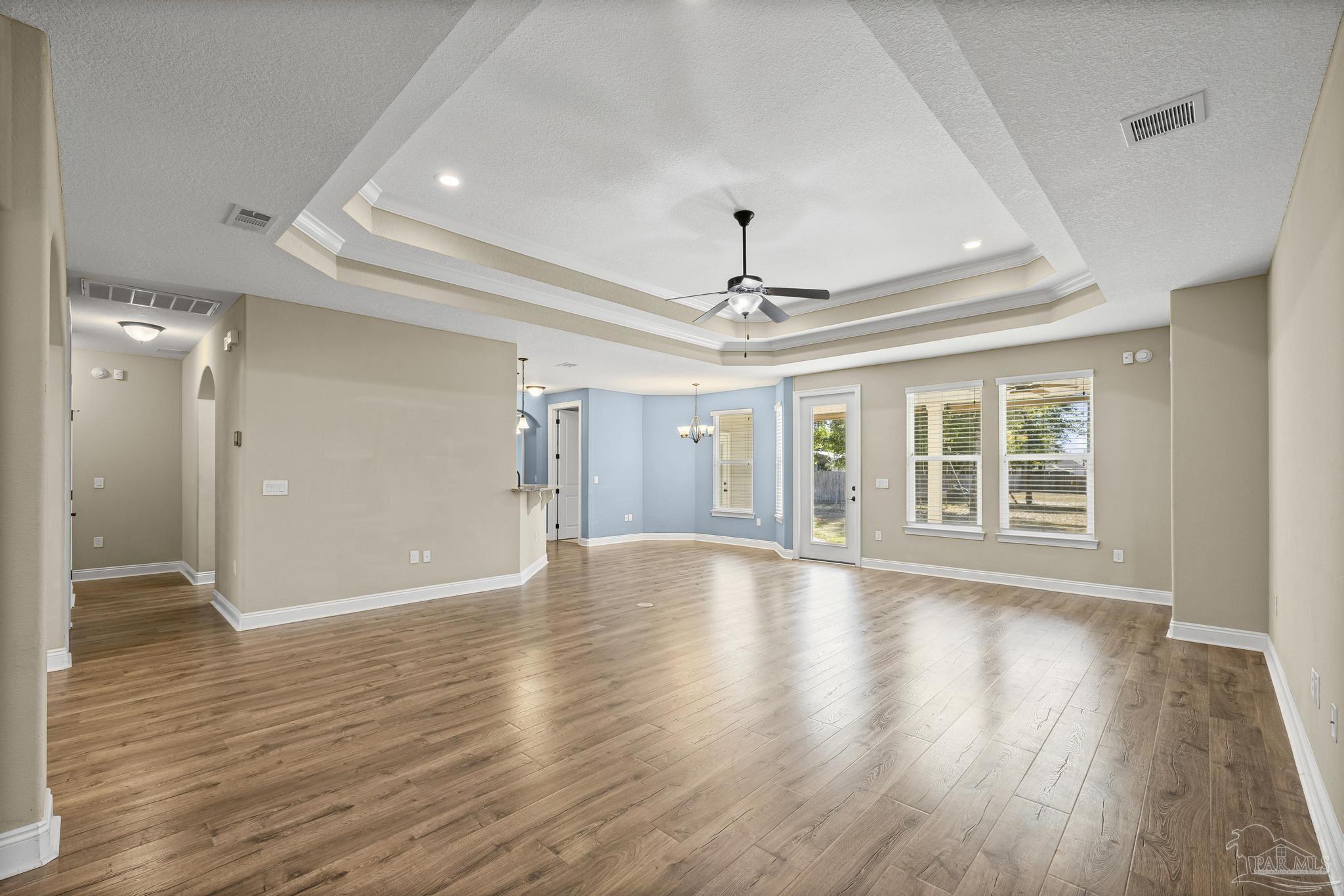 7933 Silver Maple Drive Milton, FL 32583 - Photo 23 of 70 a view of an empty room with wooden floor ceiling fan and a window