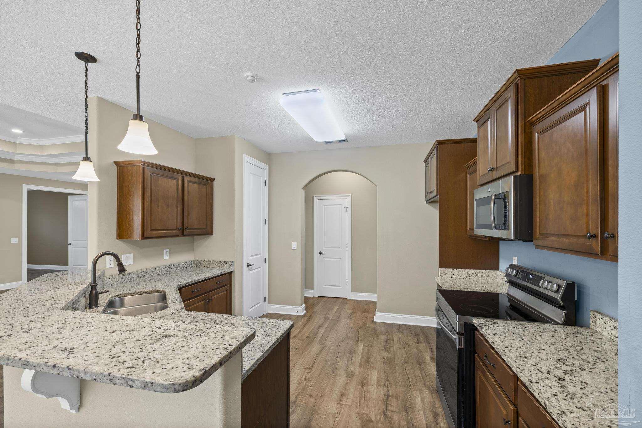 7933 Silver Maple Drive Milton, FL 32583 - Photo 28 of 70 a kitchen with stainless steel appliances granite countertop a sink stove and refrigerator