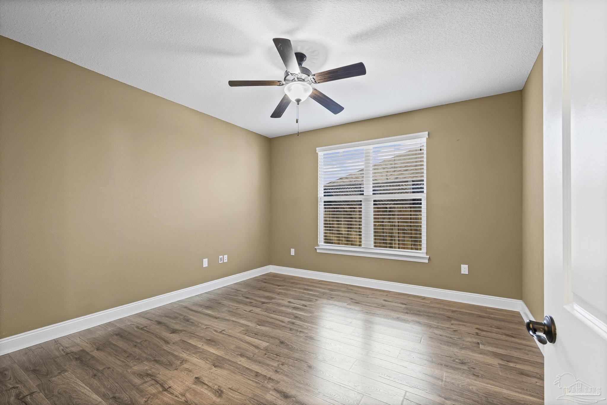 7933 Silver Maple Drive Milton, FL 32583 - Photo 34 of 70 a view of empty room with wooden floor and fan