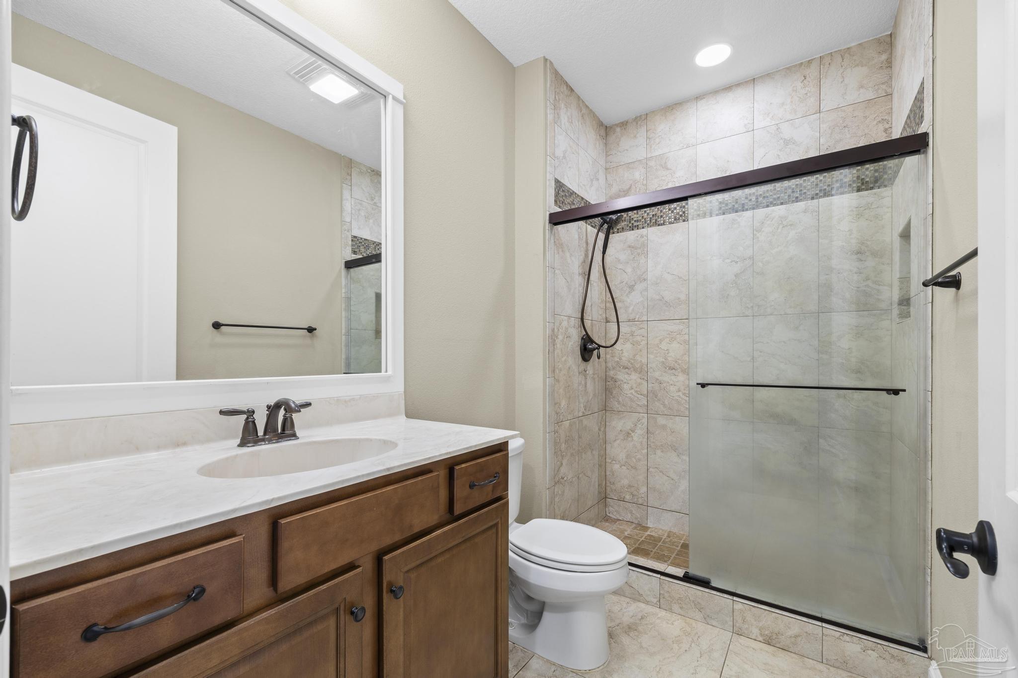 7933 Silver Maple Drive Milton, FL 32583 - Photo 44 of 70 a bathroom with a sink toilet a mirror and shower