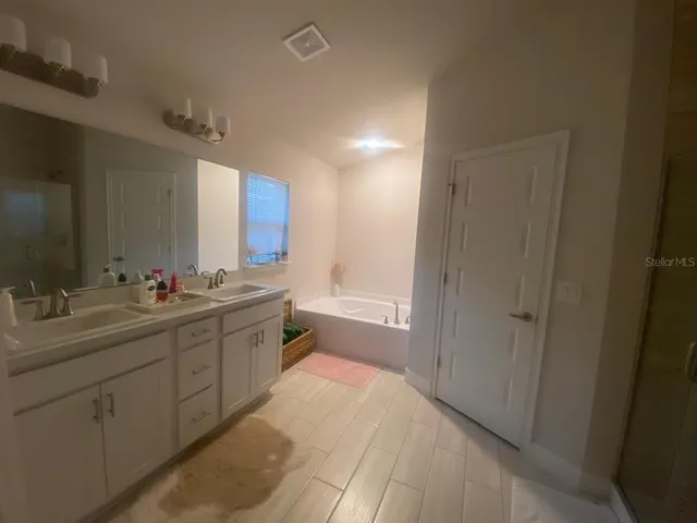 a spacious bathroom with a double vanity sink mirror and shower