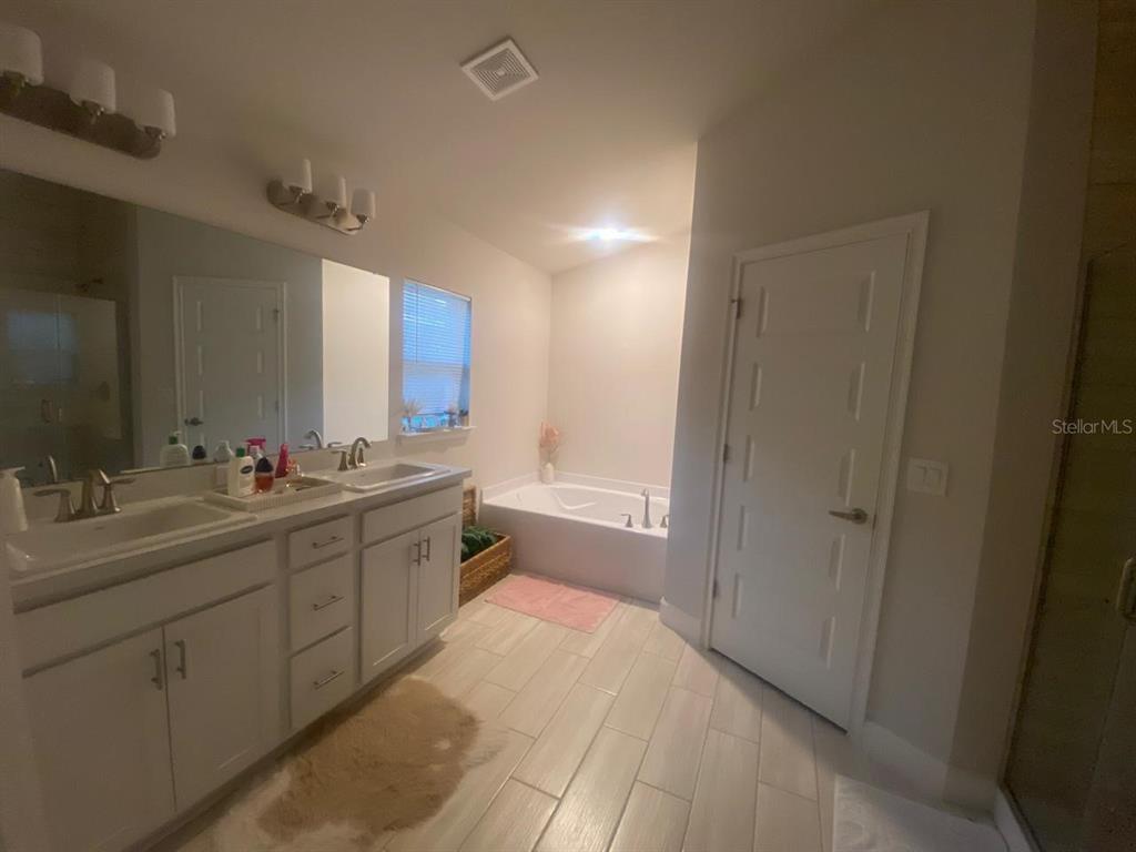 1176 Citrus Landings Boulevard Davenport, FL 33837 - Photo 11 of 15 a spacious bathroom with a double vanity sink mirror and shower