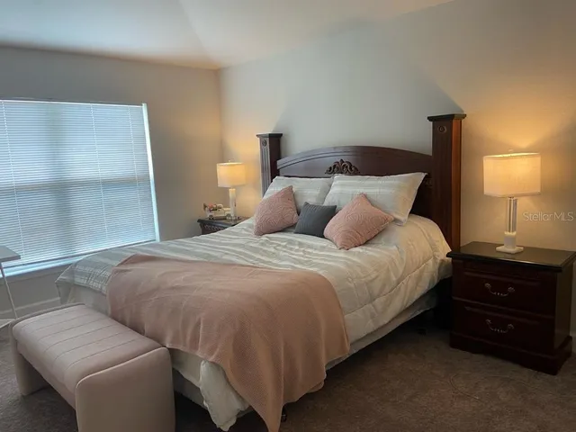 a bedroom with a bed and a lamp