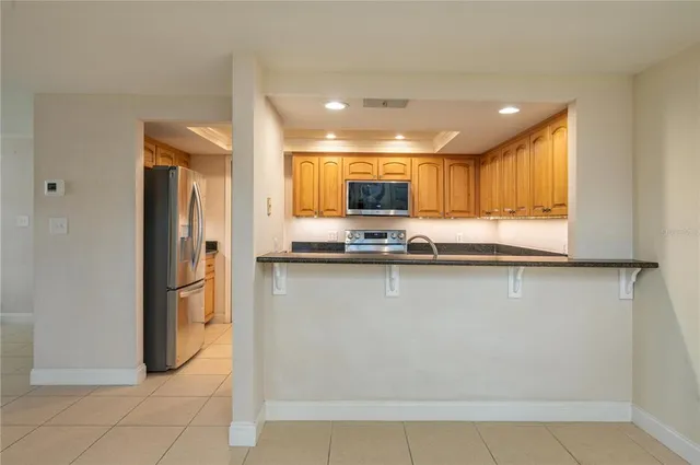 a kitchen with stainless steel appliances granite countertop a refrigerator and a stove