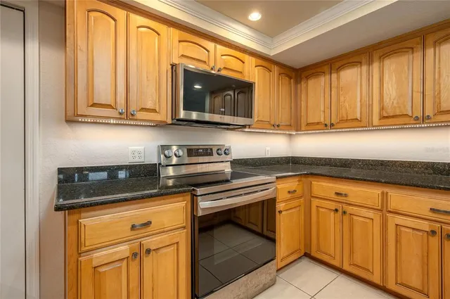 a kitchen with stainless steel appliances granite countertop white cabinets and a stove top oven