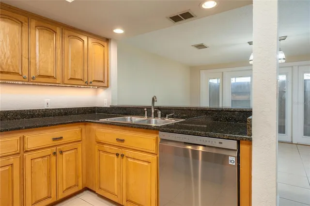 a kitchen with granite countertop a sink and white cabinets