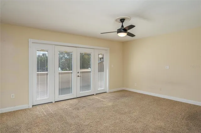 an empty room with chandelier fan