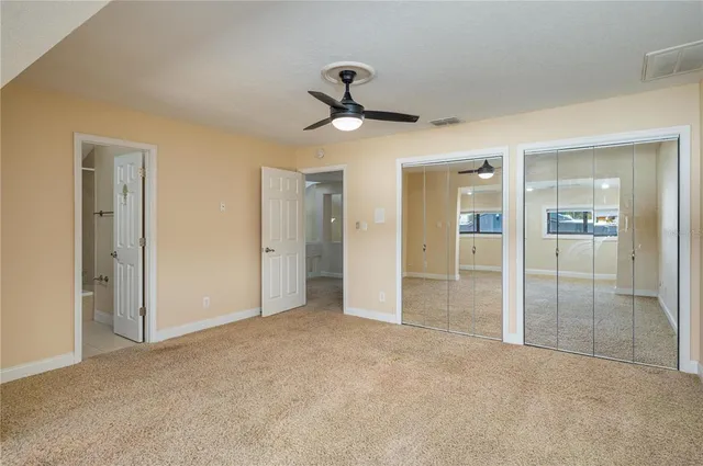 an empty room with fan and entrance