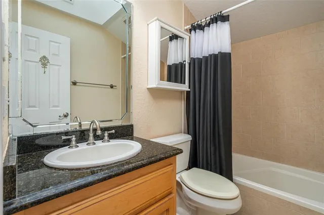 a bathroom with a sink toilet a mirror and shower