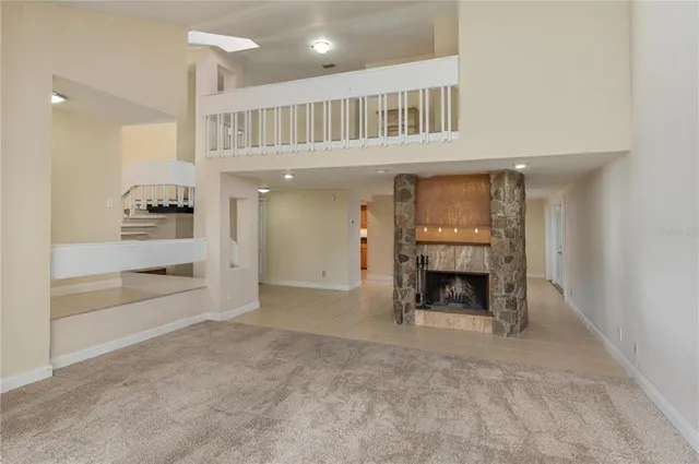 an empty room with fireplace cabinet and windows
