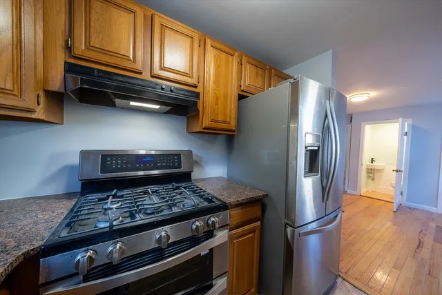 a kitchen with wooden cabinets and a stove top oven