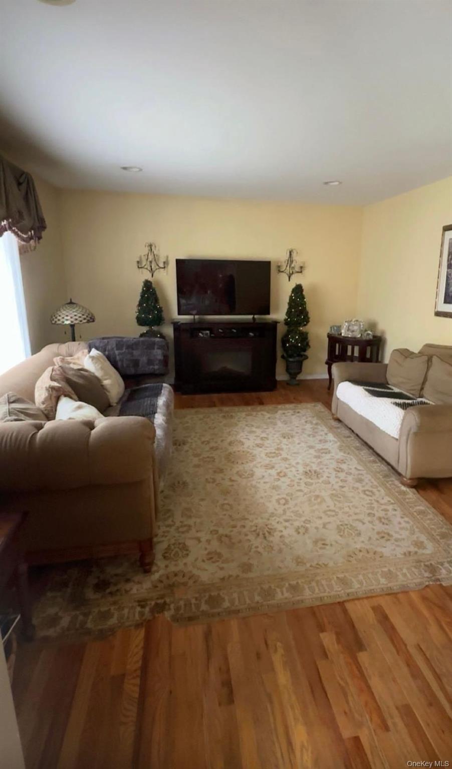 43 North Cozine Road Manorville, NY 11949 - Photo 16 of 42 a living room with furniture and a flat screen tv