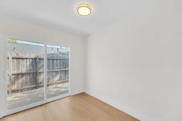 a backyard of a house with large trees and wooden fence
