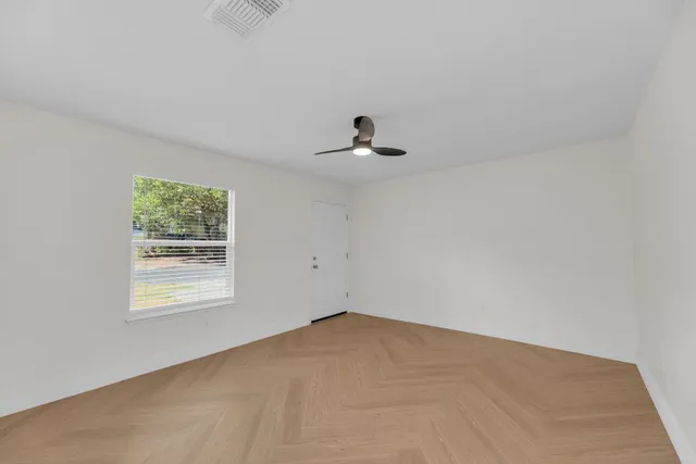 a view of an empty room with cabinet and wooden floor