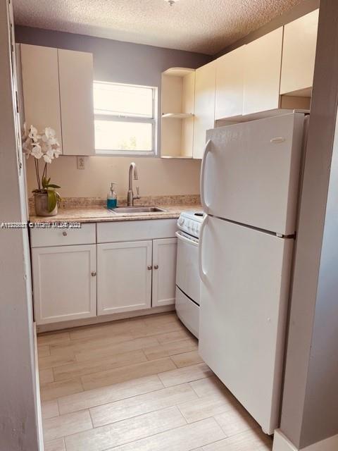 11241 Southwest 7th Terrace, Unit 1 Sweetwater, FL 33174 - Photo 25 of 34 a kitchen with white cabinets and white appliances