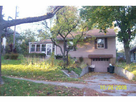 1608 Rural Street Rockford, IL 61107 - Photo 1 of 6 a view of a house with a yard and a tree in it