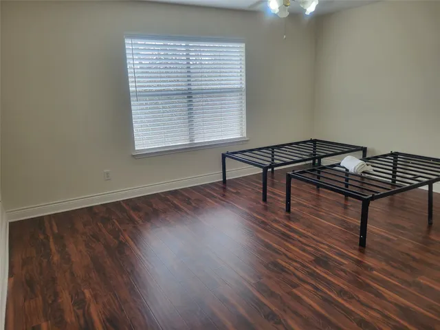 a view of a room with wooden floor and a window