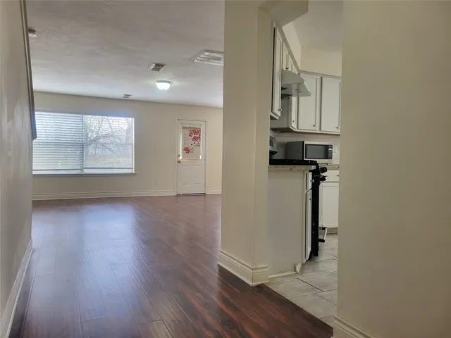 an empty room with wooden floor and a window