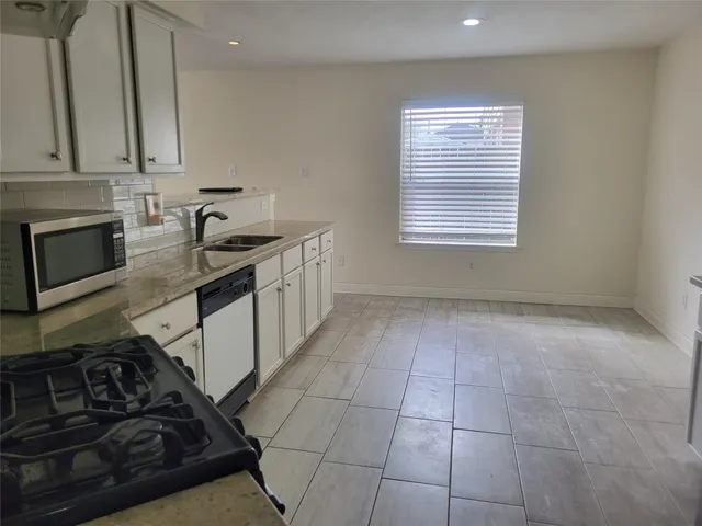 a kitchen with a stove a sink and a microwave