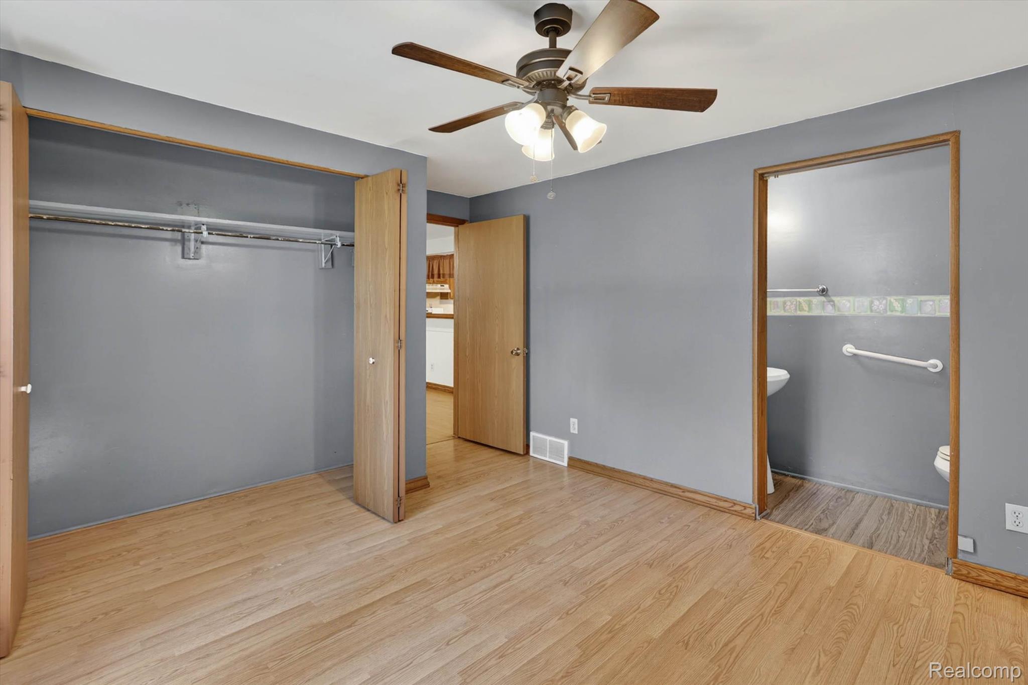 7974 West Gilford Road Reese, MI 48757 - Photo 18 of 36 Unfurnished bedroom with ensuite bathroom, light wood-style floors, a closet, and ceiling fan
