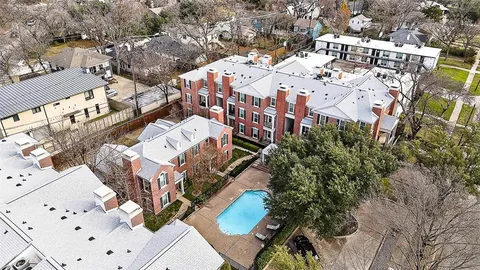 a view of an empty room with wooden floor fireplace and a window