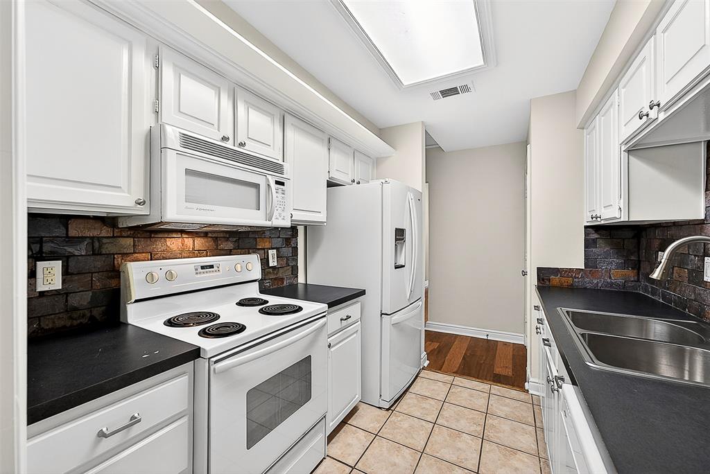 5407 Bryan Street, Unit B104 Dallas, TX 75206 - Photo 10 of 38 a kitchen with stainless steel appliances a stove a sink and a refrigerator