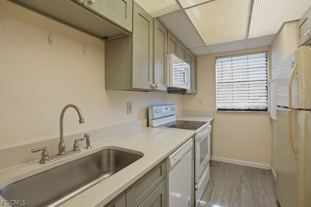 5369 Treetops Drive, Unit M102 Naples, FL 34113 - Photo 3 of 11 a kitchen with a sink cabinets and a refrigerator