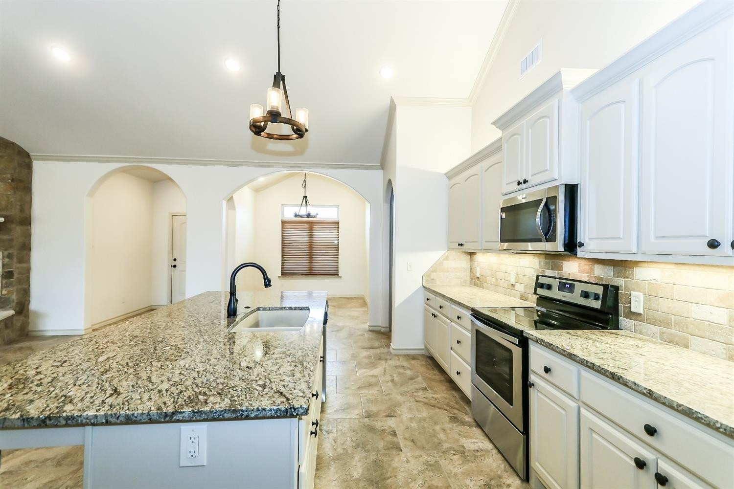 5234 Kemper Street Lubbock, TX 79416 - Photo 9 of 10 a kitchen with stainless steel appliances granite countertop a stove a sink and a white refrigerator