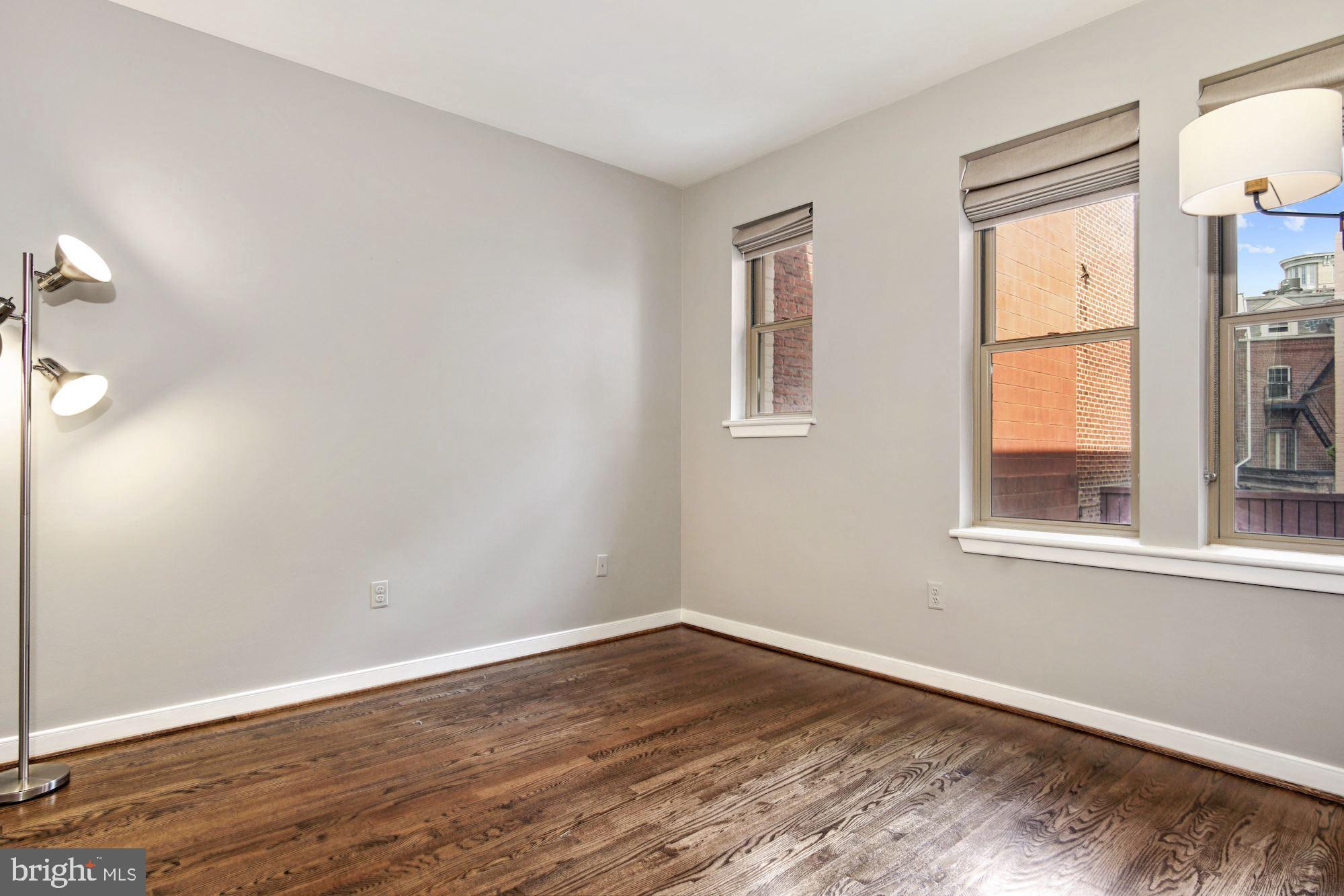 1445 N Street Northwest, Unit 202 Washington, DC 20005 - Photo 15 of 23 an empty room with wooden floor and windows