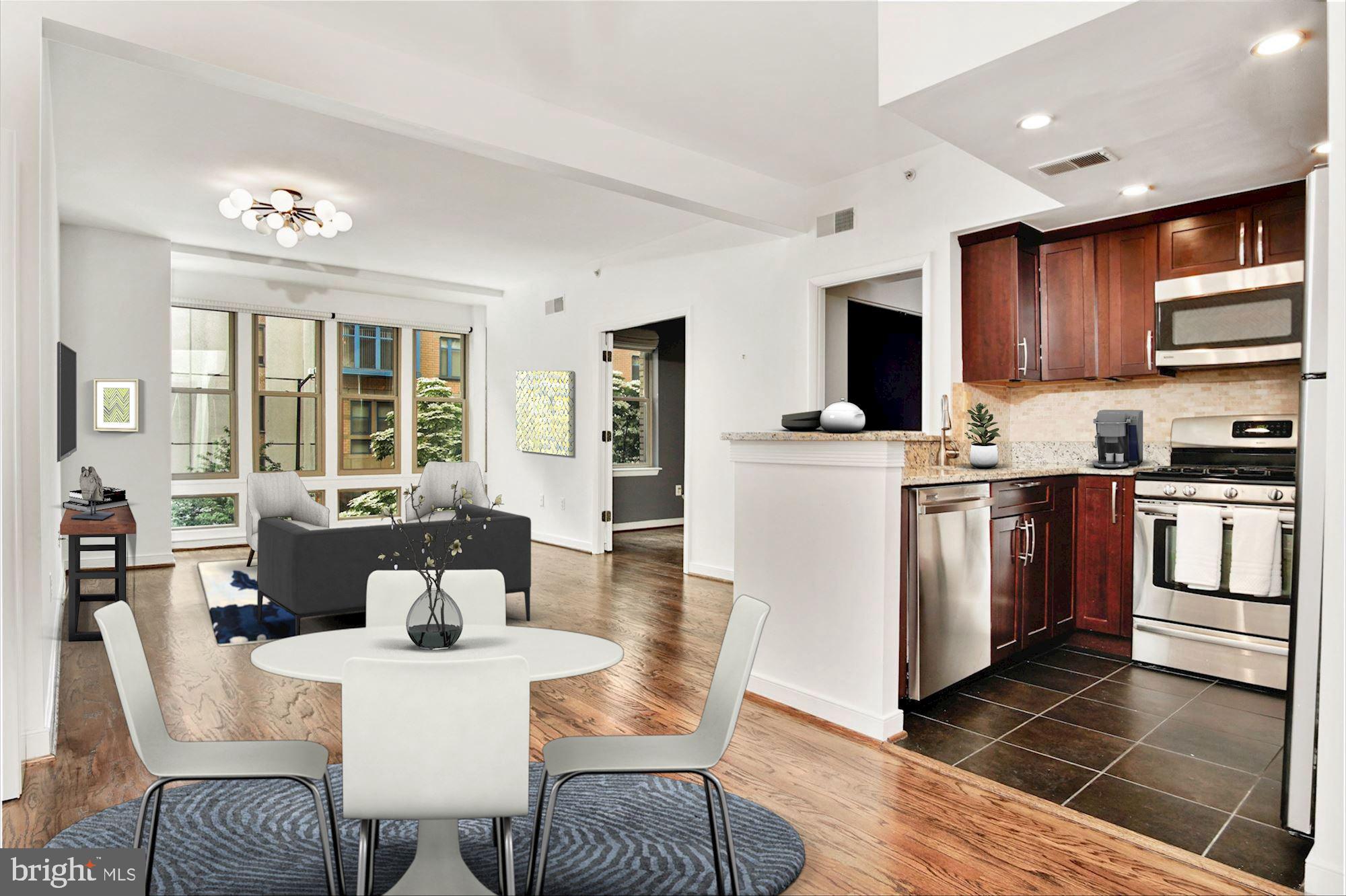 1445 N Street Northwest, Unit 202 Washington, DC 20005 - Photo 4 of 23 a dining room with stainless steel appliances kitchen island granite countertop a dining table chairs and a refrigerator
