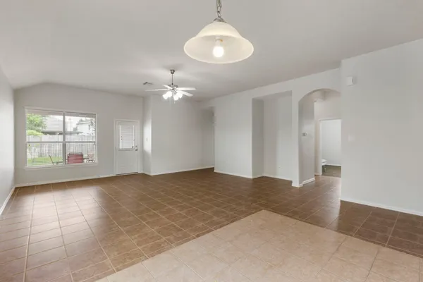 a view of an empty room with window and wooden floor