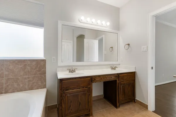 a bathroom with a granite countertop sink a large mirror and a bathtub