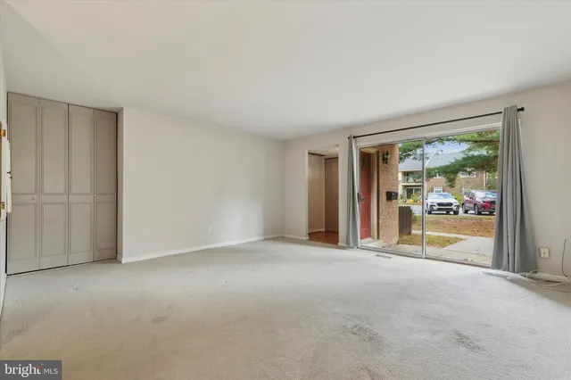 a view of a big room with wooden floor and windows