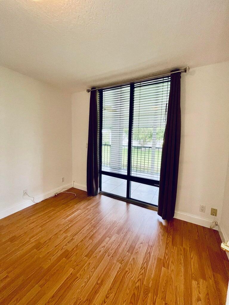 7888 La Mirada Drive Boca Raton, FL 33433 - Photo 18 of 29 a view of an empty room with wooden floor and a window